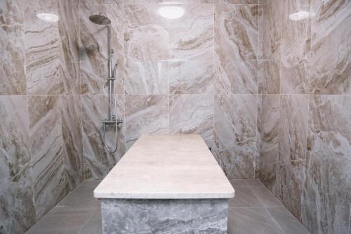 W łazience znajduje się prysznic z ławką. w obiekcie Hotel Inju w mieście Borowoje