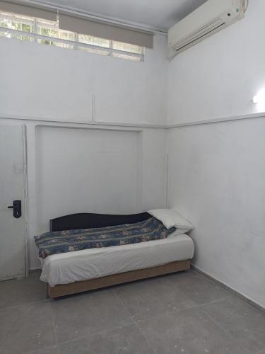 a bedroom with a bed in a white room at הבית של יעל in Tel Aviv