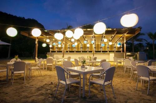 a restaurant with tables and chairs and lights at night at Pico De Loro - Myna B Studio in Nasugbu