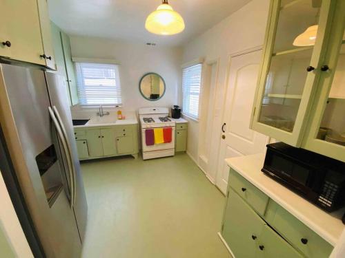 洛杉磯的住宿－Cozy 1,400sq ft 2BR+2BA WeHo Gated Home，厨房配有绿色橱柜和白色炉灶。