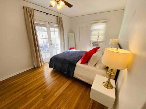 洛杉磯的住宿－Cozy 1,400sq ft 2BR+2BA WeHo Gated Home，一间卧室配有一张床和一张桌子上的台灯