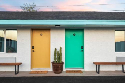 two doors on a building with a cactus and two benches at Paokalani Studio suite.hōʻoluʻolu in Chandler