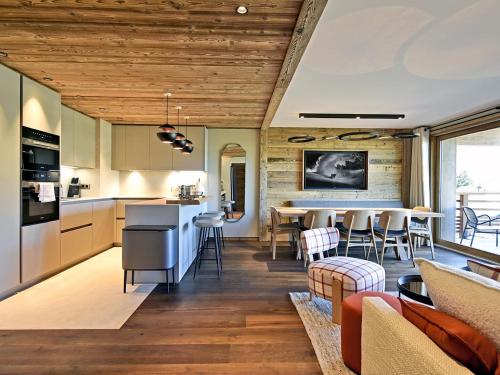Il comprend une cuisine et un salon avec des plafonds en bois. dans l'établissement Appartement lumineux avec balcon à 2 chambres doubles et services inclus, skis aux pieds - FR-1-613-65, à Les Allues