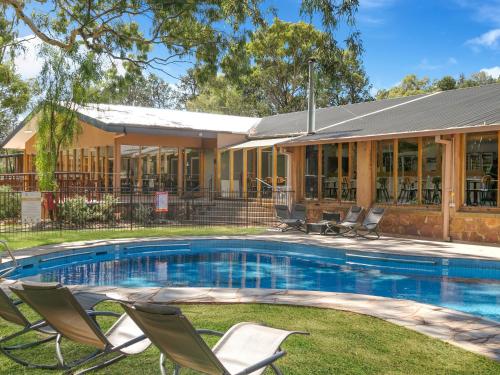 a house with a swimming pool in front of a house at Wilpena Pound Resort in Flinders Ranges