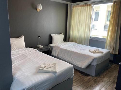 a hotel room with two beds and a window at Sun Moon Hotel in Loei