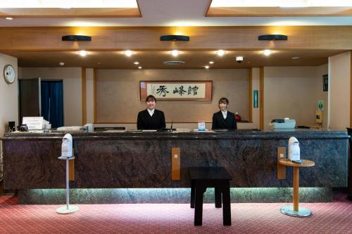 two men sitting at a counter in a room at Yufuin Hotel Shuhokan in Yufuin