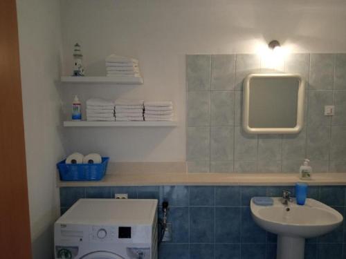 bagno con lavandino, servizi igienici e specchio di Apartment Šimi - free parking a Supetar (San Pietro di Brazza)