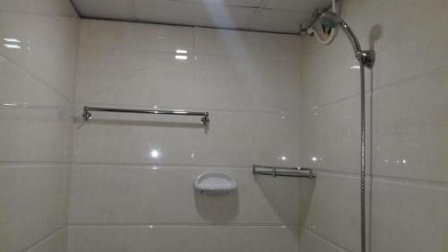 La salle de bains est pourvue d'une douche avec une porte en verre. dans l'établissement Serene Blossom Valley, à Tenkasi