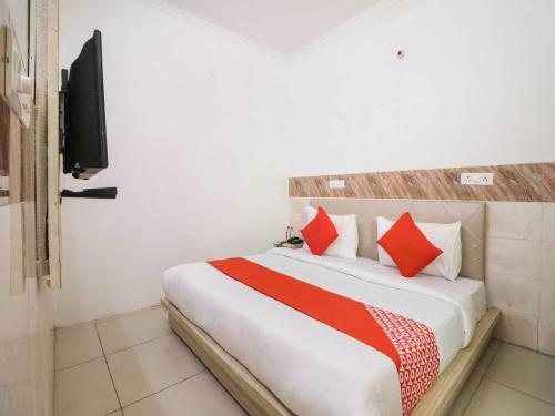 ein Schlafzimmer mit einem großen Bett mit roten Kissen in der Unterkunft Collection O 81235 Hotel Aashiyana in Neu-Delhi