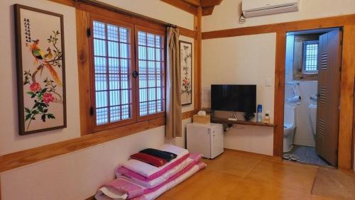 a living room with a couch and a television and a bathroom at Jeonju Hanok village Deoksugung in Jeonju