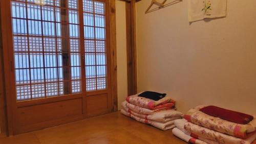 a room with two stacks of blankets in front of a door at Jeonju Hanok village Deoksugung in Jeonju