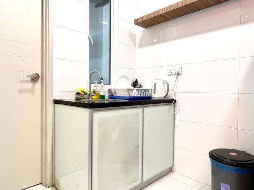 eine kleine Küche mit einem Waschbecken und einem Spiegel in der Unterkunft Grand Suite @ The Wave Residence-Cozy 2-BR Retreat: AC, Street Views & Games in Malakka