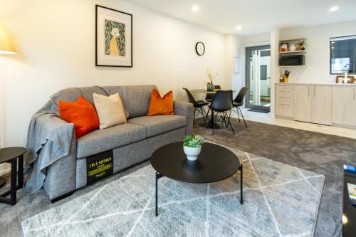 uma sala de estar com um sofá e uma mesa em The Tranquil Terrace - Zen zone 2 bed 2 bath em Christchurch