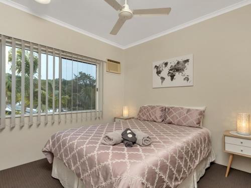 a bedroom with a large bed and a window at The Moorings at Yorkeys Knob in Yorkeys Knob