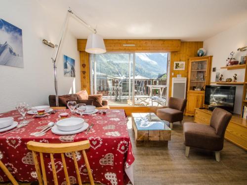 un salon avec une table et un tissu de table rouge dans l'établissement Appartement à Chamonix avec terrasse, parking, local à skis - FR-1-343-172, à Chamonix-Mont-Blanc