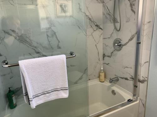 een badkamer met een douche en een witte handdoek bij SFO New Comfortable Studio in San Bruno