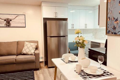 a kitchen and living room with a refrigerator and a couch at Unit #204 Cozy Mountain View 2BR in Canmore Downtown in Canmore