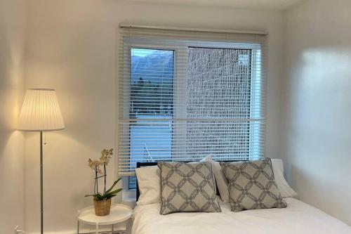 a bedroom with a bed and a large window at Unit #204 Cozy Mountain View 2BR in Canmore Downtown in Canmore