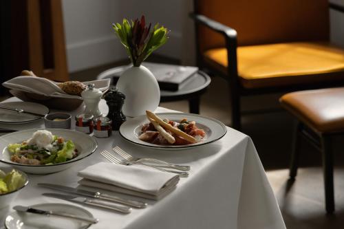 a white table with plates of food on it at Capella Sydney in Sydney