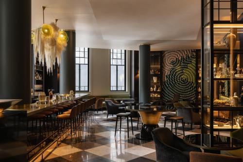 a restaurant with tables and chairs and windows at Capella Sydney in Sydney