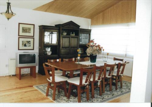 a dining room with a table and chairs and a tv at Casa Luís Gonzaga in Bragança