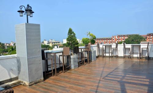 a balcony with tables and chairs on a roof at Belmont Boutique Hotel - Free Airport Shuttle Service in Negombo