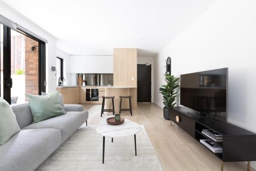 a living room with a couch and a table at Kahlo Bondi - Luxury Escape - 1 Bedroom Furnished Apartments #4 in Sydney