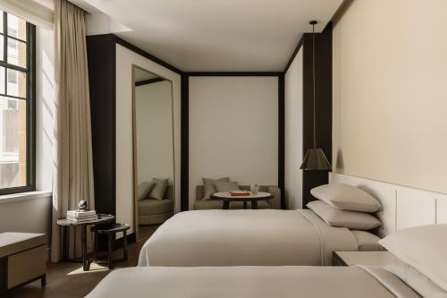 a hotel room with two beds and a chair at Capella Sydney in Sydney