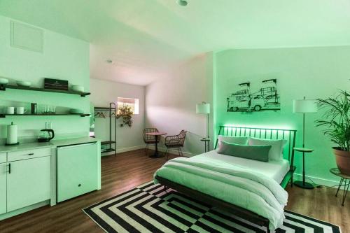 a green bedroom with a bed and a kitchen at Kaluahee Studio suite nui in Chandler