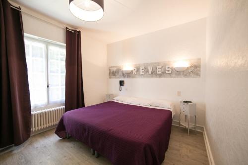 1 dormitorio con 1 cama con manta morada en Hôtel An Ti Gwenn, en Carnac