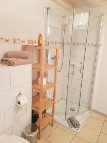 a bathroom with a shower and a wooden shelf at B-Haus Ueckermünde in Ueckermünde