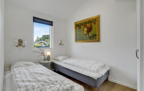 a bedroom with two beds and a picture on the wall at Nice Home In Frvang With Wifi in Fårvang