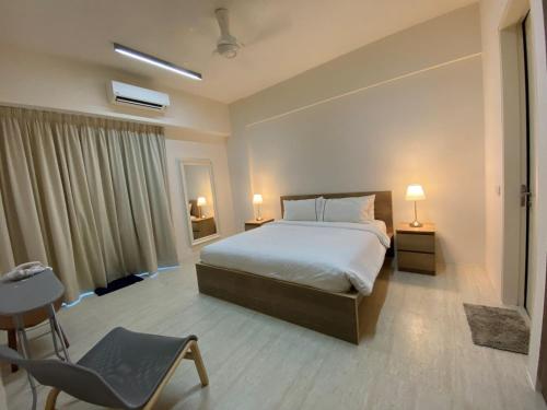 1 dormitorio con 1 cama y 1 silla en By The Sea - UBTS SMART ENTERPRISE en Batu Ferringhi