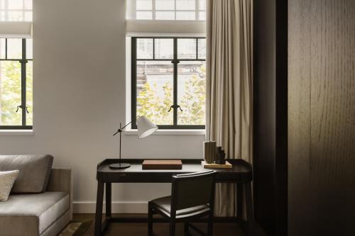 a room with a desk with a chair and a window at Capella Sydney in Sydney