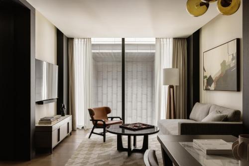 a living room with a couch and a table at Capella Sydney in Sydney