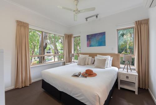 a bedroom with a large bed with a hat on it at Amphora Resort Private Apartments in Palm Cove