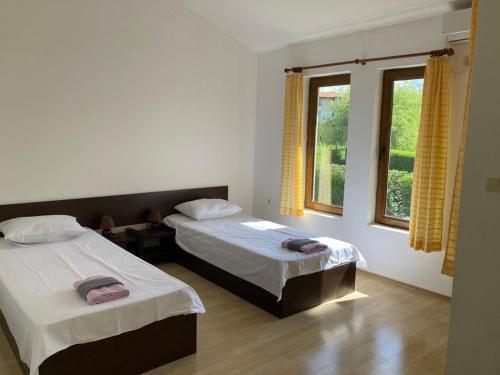 1 Schlafzimmer mit 2 Betten und einem Fenster in der Unterkunft Indigo Villas in Pismenovo
