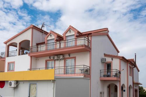 a building with a balcony on top of it at Apartmani Krka Rooms in Lozovac