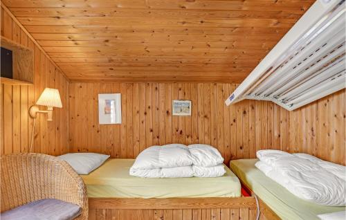 ÅlbækにあるBeautiful Home In lbk With 3 Bedrooms And Saunaの木造キャビン内のベッド2台が備わる部屋