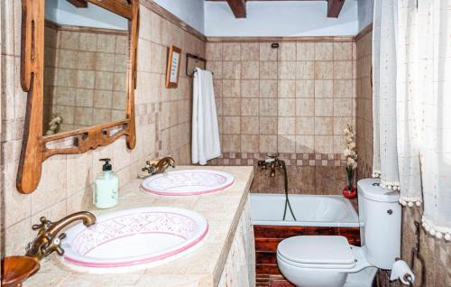 uma casa de banho com 2 lavatórios, um WC e uma banheira em Alojamiento Rural El Chico em Arenas del Rey