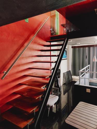 una escalera en una habitación con una pared roja en Le Blue Coast en Progreso