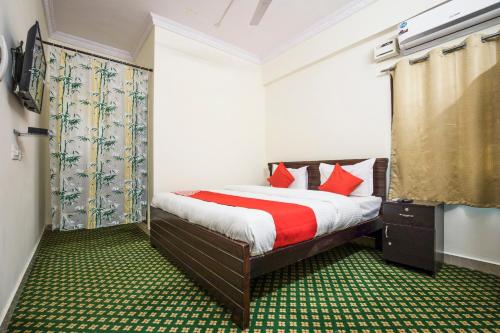 sypialnia z łóżkiem z czerwonymi poduszkami w obiekcie OYO Flagship13162 Swiss Legrand w mieście Hajdarabad
