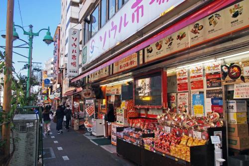 een straat met mensen die voor een winkel lopen bij Hotel RIO新宿 in Tokyo