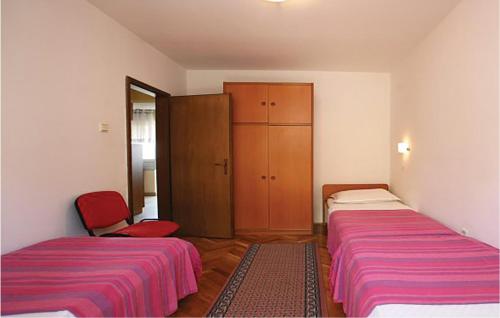 Habitación con 2 camas, armario y silla en 2 Bedroom Lovely Apartment In Labin, en Ravni