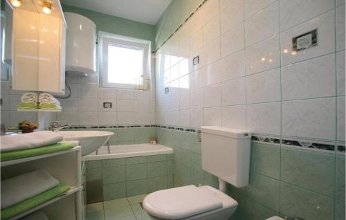 a white bathroom with a toilet and a sink at 2 Bedroom Lovely Apartment In Labin in Ravni