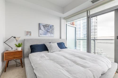 a bedroom with a large bed and a large window at Cloud 9 in Downtown Toronto in Toronto