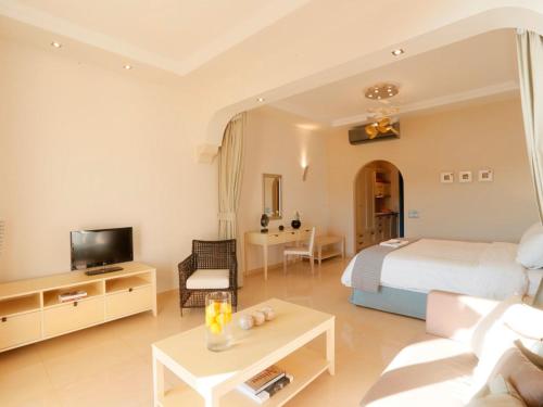 a bedroom with a bed and a living room at Pictures Suites in Agios Stefanos