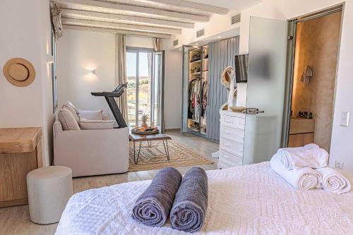 a bedroom with a bed with purple towels on it at Villa Elia by Mykonian Kazarte in Kalafatis
