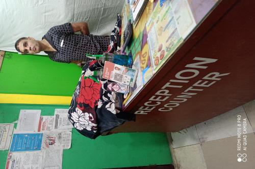 Un ragazzo steso su un letto in una libreria di OYO Nirmal Guest House a Guwahati
