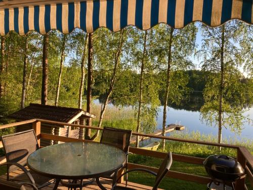 - une table et des chaises sur une terrasse avec vue sur le lac dans l'établissement Lepikkorinne Raijan Aitta, à Mikkeli